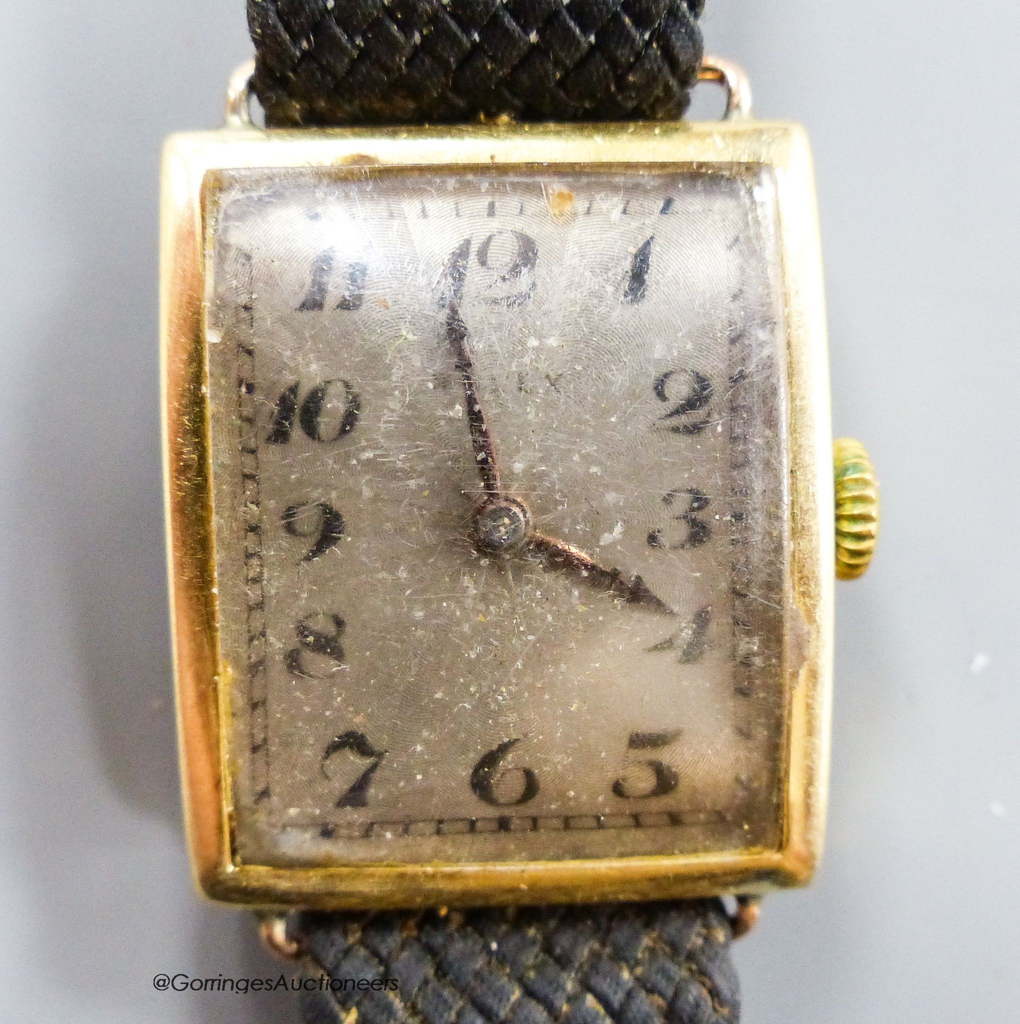A gentleman's stylish 1920's 18ct gold Rolex manual wind curved case wrist watch, with silvered sunburst Arabic dial, case diameter 25mm, on a damaged associated fabric strap, gross weight 24 grams.